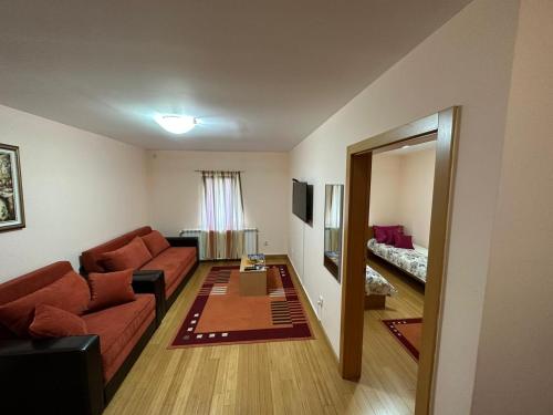 uma sala de estar com um sofá e uma mesa em Apartmani Ušće em Trstenik