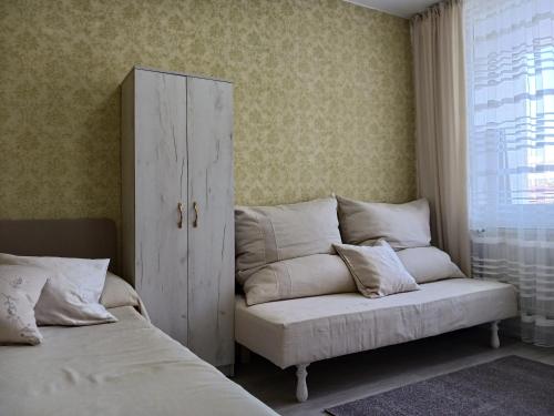 a bedroom with two beds and a couch and a cabinet at Тристаен апартамент in Sofia