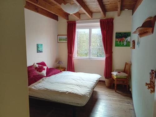 um pequeno quarto com uma cama e uma janela em Caurelgranges em Caurel