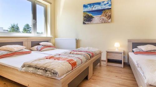 a bedroom with two beds and a window at Willa Marin in Karwia