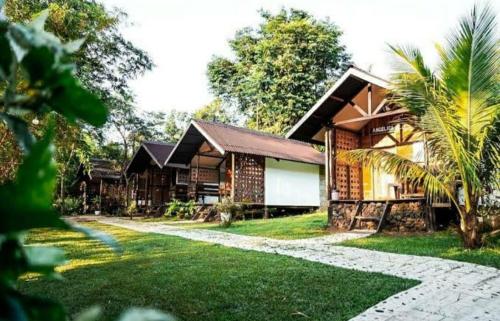 a house with a stone pathway in front of it at Banlaw Garden Resort in Puerto Princesa City