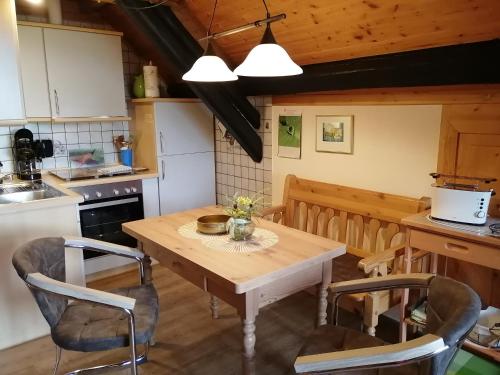 a kitchen with a wooden table and chairs at Eifelferienwohnungen "Familie Saxler" in Bereborn