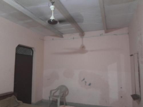 um quarto com uma parede branca e uma cadeira em Giriraj Darshan em Govardhan