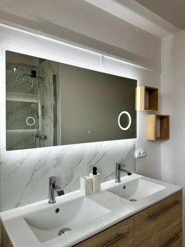 une salle de bain avec un lavabo blanc et un miroir dans l'établissement Charmant & Spacieux appartement à Perpignan, à Perpignan