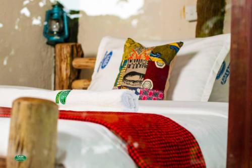 a white bed with a pillow on top of it at Sipi Falls Lodge in Sipi