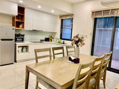uma cozinha com uma mesa de madeira com um vaso de flores em 5Bedroom Villa close to the sea with a Lake view em Ha Long
