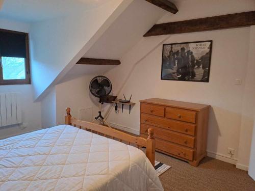 a bedroom with a bed and a wooden dresser at Les chaumières du Chêne in Pouillé