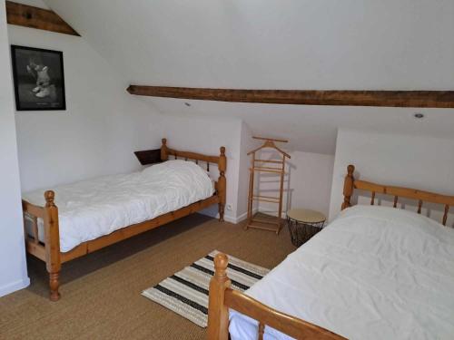 a bedroom with two beds and a ladder in it at Les chaumières du Chêne in Pouillé