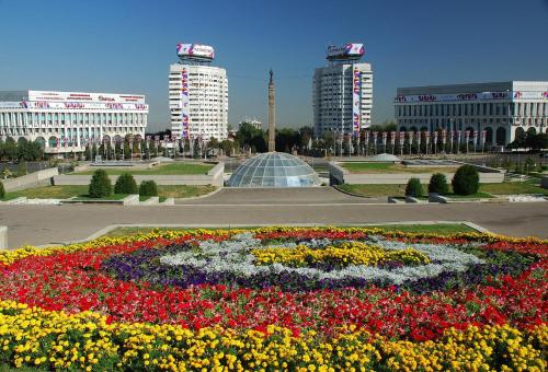 a flower garden in the middle of a city with buildings at Nadezhda Apartments in Samal in Almaty