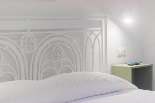 1 cama blanca con cabecero blanco en un dormitorio en Al Ciglio Holiday House Amalfi Coast, en Scala
