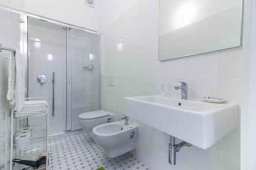 Baño blanco con lavabo y aseo en Al Ciglio Holiday House Amalfi Coast, en Scala