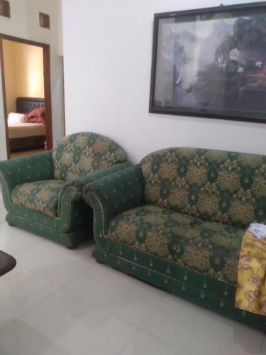 a couch and a chair in a living room at House 08 in Pekalongan