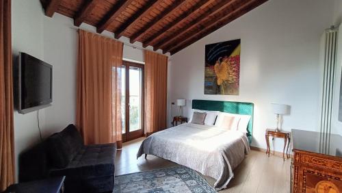 a bedroom with a bed and a flat screen tv at Suite with Lake Como view in Colico