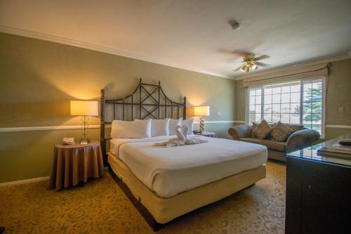 a bedroom with a large bed and a living room at The Morgan Hotel San Simeon in San Simeon