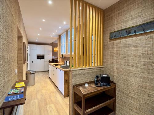 Il comprend une cuisine avec des murs jaunes, du parquet et une table. dans l'établissement Rouen Hypercentre - Le relais des Amis, à Rouen