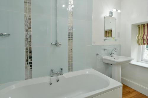 Baño blanco con bañera y lavamanos en The Crown Hotel, en Exford