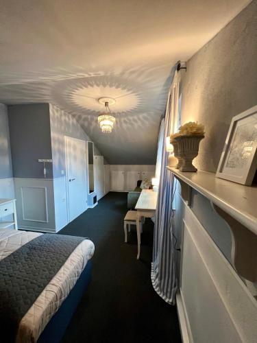 a hotel room with a bed and a desk in it at Cottage & Garden & Sauna am See in Wettringen