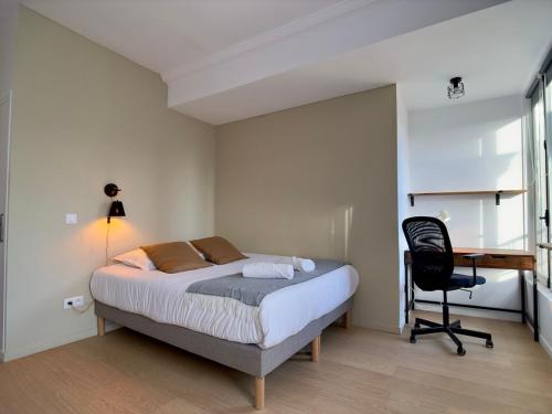 a bedroom with a bed and a desk and a chair at Rouen Hypercentre - Le relais des Amis in Rouen