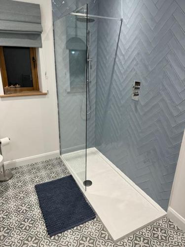 a shower with a glass door in a bathroom at Highfield in Rous Lench
