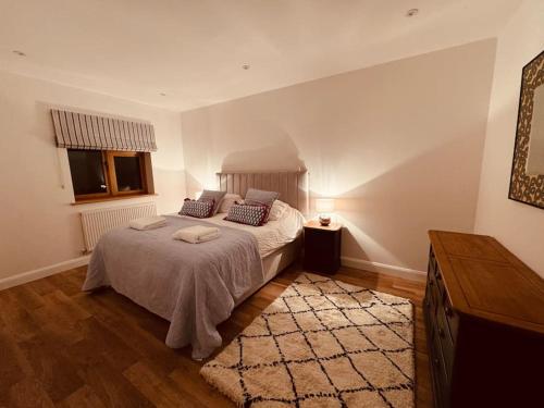 a bedroom with a large bed and a rug at Highfield in Rous Lench