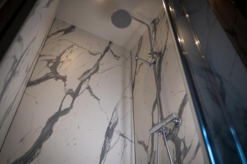 a shower in a bathroom with a marble wall at HarTeluk Joure in Joure