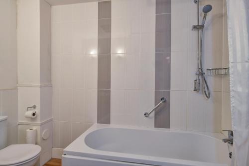 a bathroom with a white tub and a toilet at The Crown Hotel in Exford