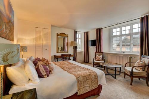 1 dormitorio con 1 cama grande y sala de estar en The Crown Hotel en Exford