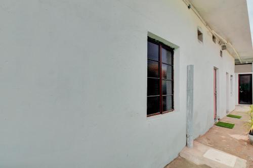 SPOT ON Hotel BRC Inn في ناغبور: جدار أبيض مع نافذة على جانب المبنى