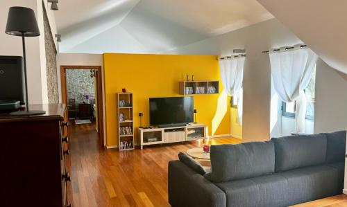 a living room with a couch and a tv at Casa dos Arrifes in Funchal