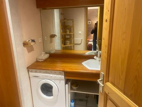 une salle de bain avec une machine à laver et un lavabo dans l'établissement Cosy appartement avec terrasse et vue dégagée, à La Salle Les Alpes