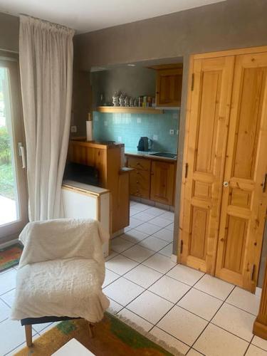 - une cuisine avec des placards en bois et une chaise dans l'établissement Cosy appartement avec terrasse et vue dégagée, à La Salle Les Alpes