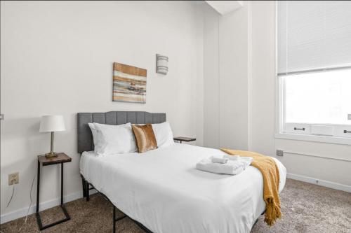 sypialnia z dużym białym łóżkiem i oknem w obiekcie CozySuites - 2BR with Direct Skybridge Access #6 w mieście Indianapolis