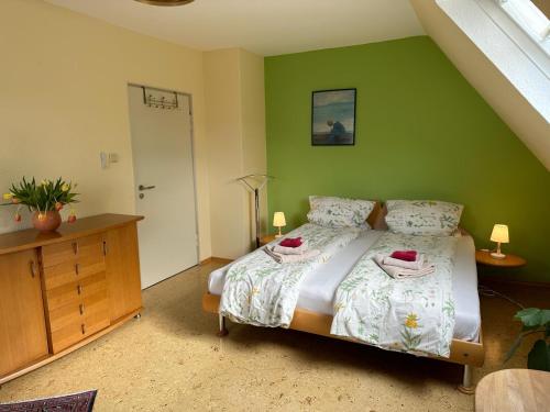 a bedroom with a bed and a green wall at Terrassenwohnung in Neustadt an der Weinstraße