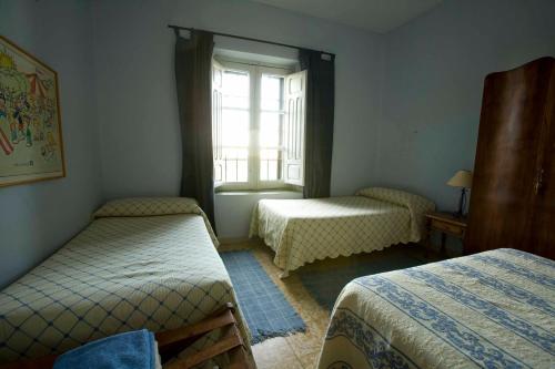 1 dormitorio con 2 camas y ventana en El Molino de Valeriano - Casa Rural, en Sancti-Spíritus
