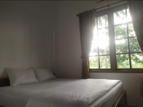 a bedroom with a bed and a window at Puri Sanghyang in Batukaras