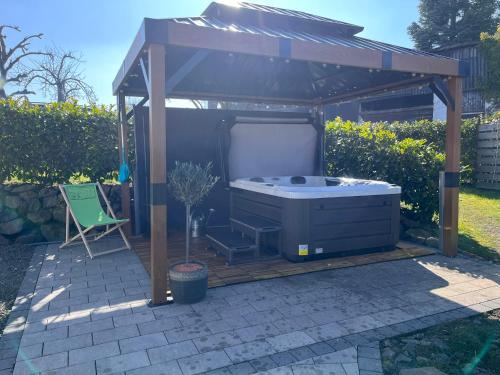 bañera de hidromasaje en un cenador en un patio en Eifelferienhaus An der Kapelle - kostenlose Sauna, Ofen, en Kerschenbach