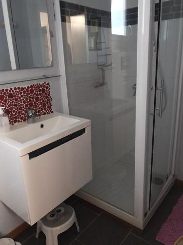 une salle de bain avec un lavabo blanc et une douche dans l'établissement Charmante Maison, terrasse vue mer, à Les Sables-dʼOlonne