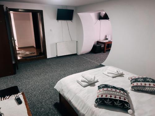 Zimmer mit einem Bett mit zwei Kissen und einem Spiegel in der Unterkunft Casa ANSI 