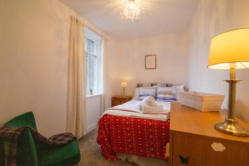 a bedroom with a bed and a desk and a lamp at 5 wheelhouse apartments in Lochinver