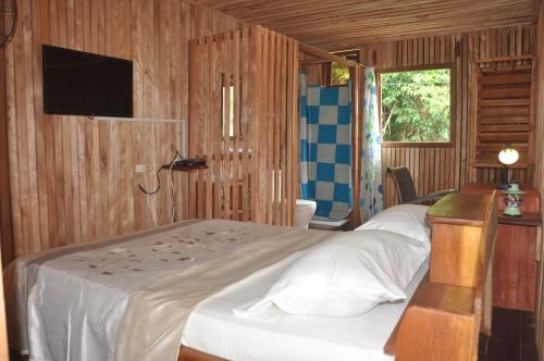 1 dormitorio con 2 camas y TV. en KSW BASE NAUTIQUE Isonalambo en Kribi
