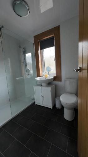 y baño con aseo, lavabo y ducha. en Number 4, Loch Shiel View, en Glenfinnan