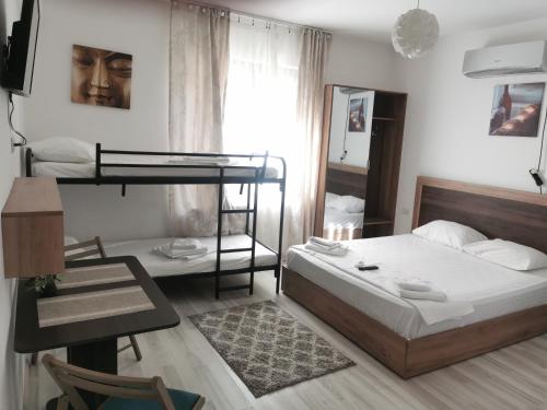 a bedroom with a bed and a desk and a bunk bed at Hotel Ipsilanti in Iaşi