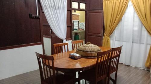 a dining room table with a hat on top of it at Homestay Bonda Azizah 11-13pax in Kota