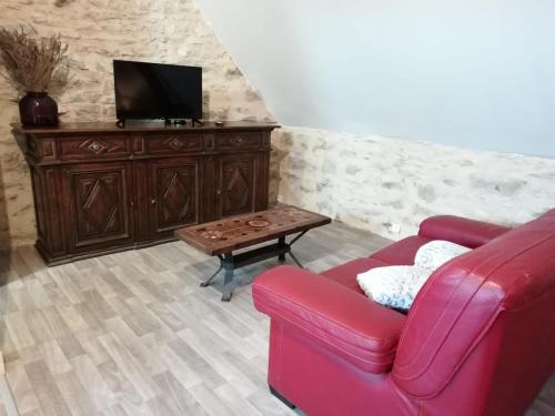 Sala de estar con sofá rojo y mesa de centro en Le Fenil, en Floirac