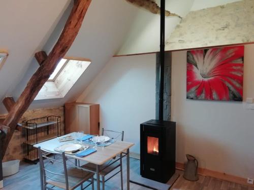 a dining room with a table and a stove at Le Fenil in Floirac