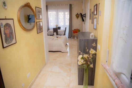 a living room with yellow walls and a vase of flowers at Appartamento La Coccinella in Lido di Ostia