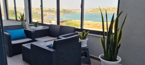 Zimmer mit Stühlen, Topfpflanzen und Fenstern in der Unterkunft Cazino Apartamento III in Praia