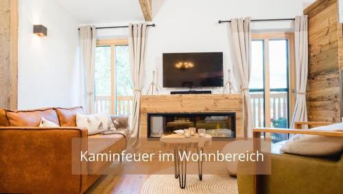 sala de estar con sofá y chimenea en Chalet WaldHäusl luxuriöse Ferienwohnungen mit Sauna & Whirlpool, Kamin, Balkon oder Terrasse mit Bergblick, en Heiligenblut
