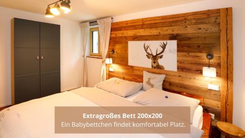 1 dormitorio con 1 cama y una foto de un ciervo en la pared en Chalet WaldHäusl luxuriöse Ferienwohnungen mit Sauna & Whirlpool, Kamin, Balkon oder Terrasse mit Bergblick, en Heiligenblut