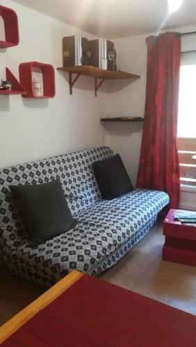 - un lit dans l'angle de la chambre dans l'établissement Superbe studio aux 7 Laux, à La Ferrière